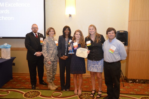 Tim St. Jean (l), South Florida Chapter Schools/University director; Col. Maria Barrett, USA, chapter president; and Dr. Merilyn Johnson (3rd from l), a secondary STEM supervisor for Broward County Public Schools, present a 2013 STEM Excellence Award to Elizabeth Garrison (3rd from r), who is joined by her parents.